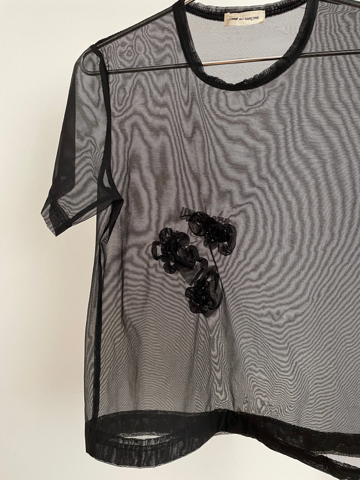 Detail view of vintage womens Comme des Garçons black short sleeve mesh top with rosette appliqués