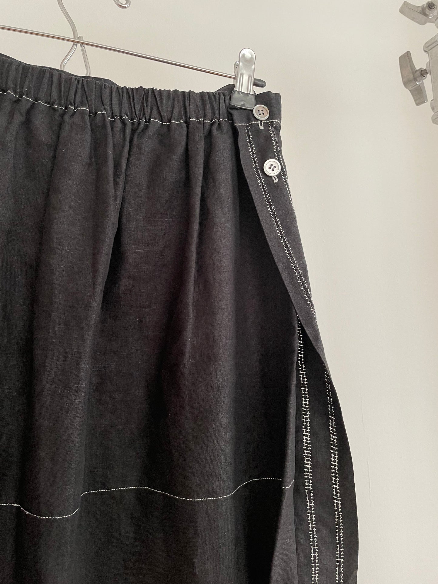Detail view of womens vintage Issey Miyake black skirt with white contrast stitch