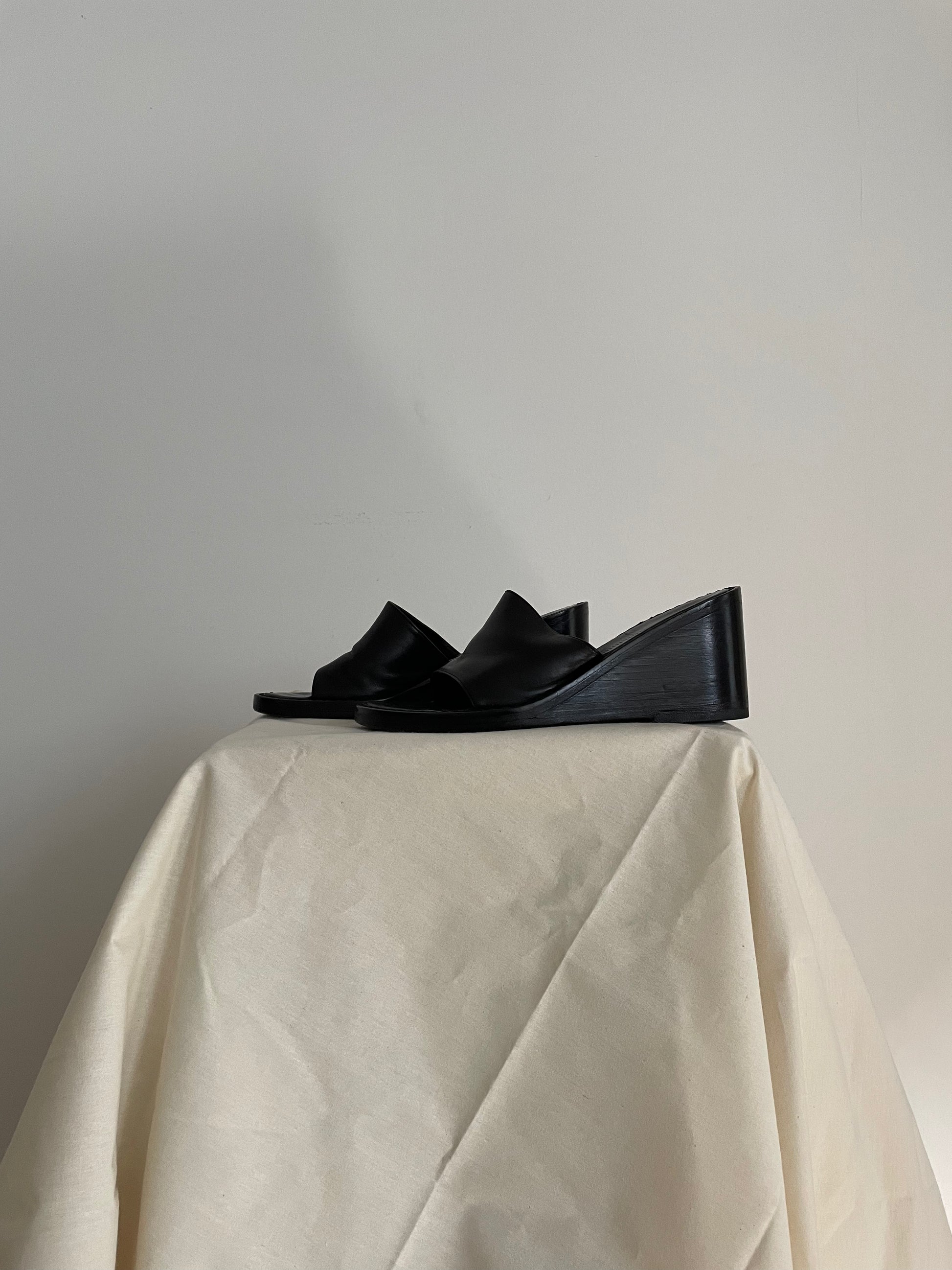 Side view of womens black Ann Demeulemeester wedge sandals